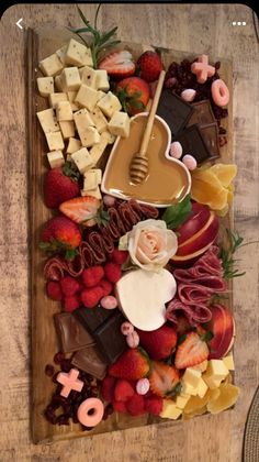 a platter filled with assorted fruits and chocolates on top of a wooden table