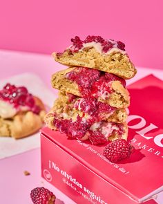 raspberry and white chocolate cookies stacked on top of each other in a pink box