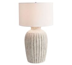 a white ceramic lamp with a beige shade