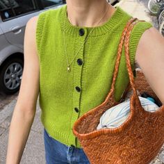 a woman carrying a woven purse on the street