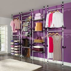 an organized closet with purple walls and shelving units for clothing, shoes, and other items