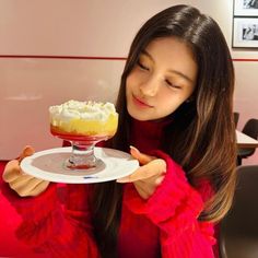 a woman holding a plate with a dessert on it