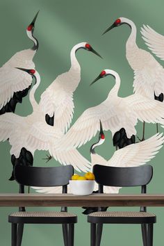 four white birds sitting on chairs around a table