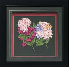 some flowers that are in a black frame