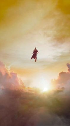 a man flying through the air on top of clouds