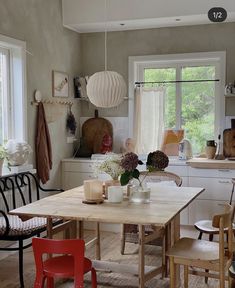 a dining room table and chairs in front of a window