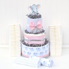 a three tiered cake with an elephant on top and other items around it for decoration