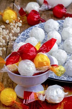 white and red candies in a bowl on a wooden table with other candy items