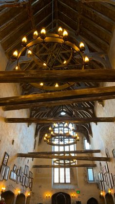 the inside of an old building with wooden beams and chandeliers