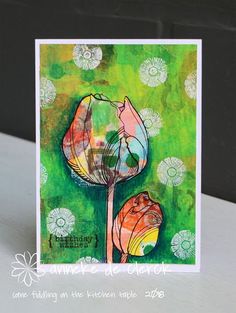 a close up of a greeting card with flowers on the front and green back ground