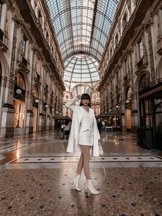 a woman is standing in an indoor shopping mall