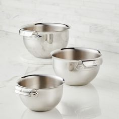 three stainless steel mixing bowls on a marble counter