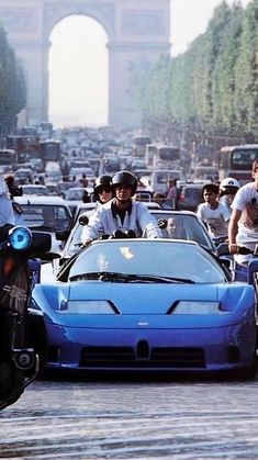 several police officers riding motorcycles and cars on a busy street in front of the eiffel tower