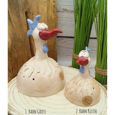 two ceramic chickens sitting on top of a table