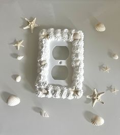 a decorative light switch cover with seashells around it