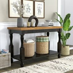 a table with baskets and plants on it in a living room next to a wall