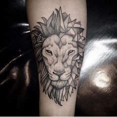 a black and white lion tattoo on the left arm with geometric shapes around it's head