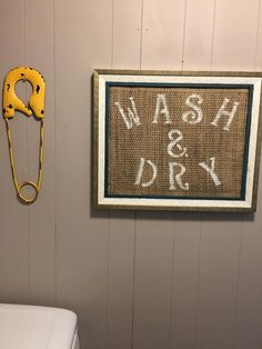 a wash and dry sign hanging on the wall next to a toilet