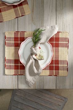 a place setting on a wooden table with napkins and utensils in front of it