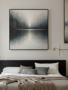 a large bed sitting under two paintings on the wall