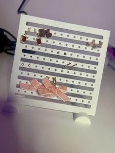 a white card with pink bows and pins attached to the back of it, sitting on a table