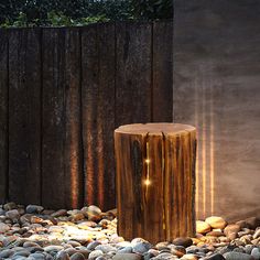 a wooden table sitting on top of a pile of rocks next to a tree stump