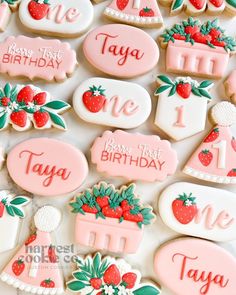 some decorated cookies are sitting on a white table together with the words happy 1st birthday