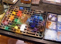 an assortment of paints and other items on a table