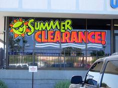 a car parked in front of a building with the words summer clearance written on it