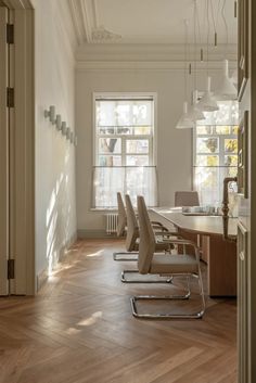 an empty office with chairs and desks in the middle of the room, looking into the hallway