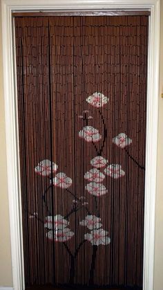 a bamboo screen with flowers painted on it in front of a door that is closed