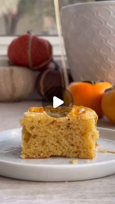 a piece of cake sitting on top of a white plate next to oranges and other fruit