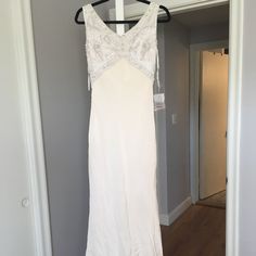 a white dress hanging on a hanger in a room