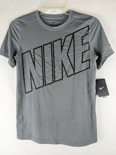 New with Tags Nike Boys Gray Short Sleeve Dri-Fit Athletic Activewear Shirt  Item #827994 Youth Boys Size: Large Color:  Gray with black NIKE logo on front Swish on sleeve Round collar Short Sleeves Dri-Fit Tagless Retail MSRP:  $25 Material:  92% Polyester, 8% Spandex Material care:  Machine wash, cold and Tumble dry, low Approximate measurement of garment, laying flat: Armpit to Armpit:  16-1/2" Length:  23" Nike Fitted Sports Shirt, Nike Fitted Shirt For Sports, Fitted Nike Sports Shirt, Fitted Nike Shirt For Sports, Nike Gray Tops With Letter Print, Nike Gray T-shirt With Logo Print, Sports Graphic Print Gray Shirt, Sporty Fitted Tops With Logo, Fitted Sporty Tops With Logo