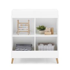 a white bookcase with three shelves filled with toys