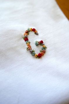 a white t - shirt with colorful beads on it