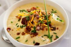 a white bowl filled with potato soup topped with bacon and cheese