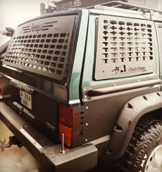 the back end of a green jeep parked in a garage