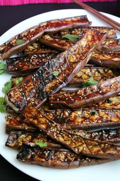 grilled eggplant on a white plate with chopsticks