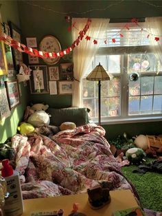 a messy bedroom with lots of clutter on the floor and decorations hanging from the window