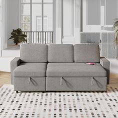 a couch sitting on top of a rug in a living room next to a window