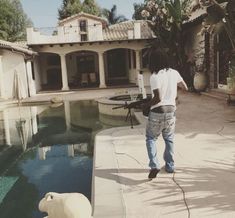 a man standing in front of a pool next to a white bird