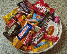 a bowl filled with candy and candies on top of a granite counter next to the words life is short eat the good candy first