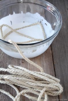 some twine is in a glass bowl on a wooden table