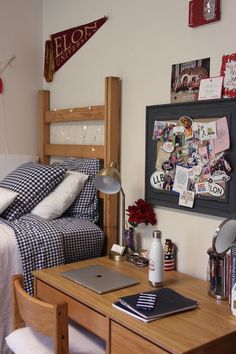 a bed room with a neatly made bed and a laptop on a desk next to it