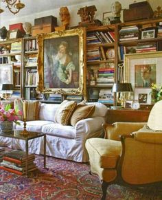 a living room filled with furniture and bookshelves covered in pictures on the wall