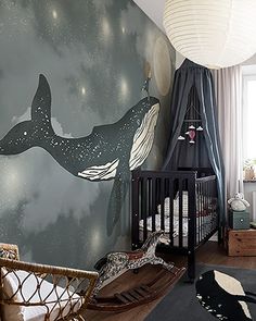 a baby's room with a whale mural on the wall and a crib