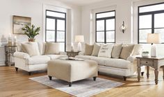 a living room filled with lots of furniture in it's white and beige color scheme