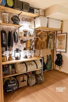 the inside of a room with many items on shelves and bags hanging from the wall