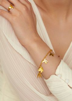 a close up of a person wearing a bracelet with gold birds on it's arm